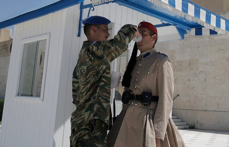 Μέλος της Προεδρικής φρουράς προσφέρει νερό σε Εύζωνα που εκτελεί την υπηρεσία του στο Μνημείο του Αγνώστου Στρατιώτη (φωτ.: ΑΠΕ-ΜΠΕ / Κώστας Τσιρώνης)