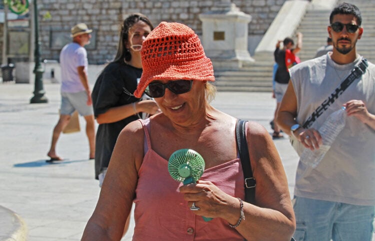 Ανεμιστήρας χειρός για την αντιμετώπιση των υψηλών θερμοκρασιών στο κέντρο της Αθήνας (φωτ.: ΑΠΕ-ΜΠΕ / Αλέξανδρος Βλάχος)