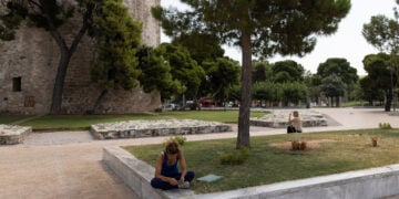 Γυναίκα κάθεται κάτω από τη σκιά ενός δέντρου ώστε να προστατευτεί από τις υψηλές θερμοκρασίες και τον καυτό ήλιο, Θεσσαλονίκη (φωτ.: ΑΠΕ-ΜΠΕ / Αχιλλέας Χήρας)