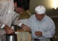 Από αριστερά, ο Con Pape με τον Δήμο Μιχαλόπουλο ενώ ασχολούνται με τις κυψέλες τους (φωτ.: neoskosmos.com)