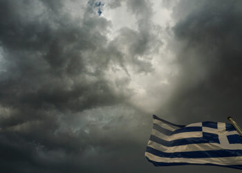 Ελληνική σημαία ανεμίζει με φόντο σύννεφα καταιγίδας στην πόλη των Τρικάλων (φωτ.: EUROKINISSI / Θανάσης Καλλιάρας)
