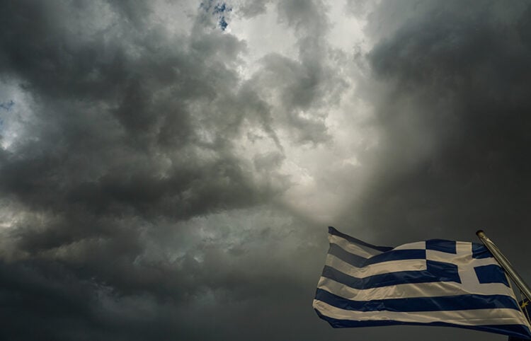 Ελληνική σημαία ανεμίζει με φόντο σύννεφα καταιγίδας στην πόλη των Τρικάλων (φωτ.: EUROKINISSI / Θανάσης Καλλιάρας)