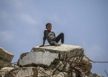 Μικρός Παλαιστίνιος κάθεται πάνω σε ερείπια κτηρίου στο βόρειο τμήμα της Λωρίδας της Γάζας, μετά από ισραηλινό βομβαρδισμό (φωτ.: EPA/Mohammed Saber)