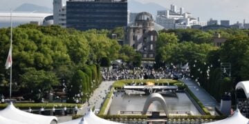 Περιστέρια πετούν στον ουρανό στη διάρκεια της τελετής μνήμης για την επέτειο ρίψης της ατομικής βόμβας στη Χιροσίμα. Στο βάθος διακρίνεται το κτήριο με τον θόλο της ατομικής βόμβας στο Πάρκο Ειρήνης της πόλης (φωτ.: EPA/JIJI Press)