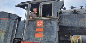 Ο συγγραφέας στο ιστορικό βαγόνι μεταφοράς των προγόνων μας που εκτίθεται στον σιδηροδρομικό σταθμό του Καρς, τον Ιούλιο του 2024 (φωτ.: Ανδρέας Αθανασιάδης)