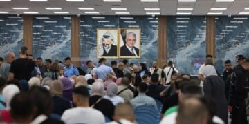 Μαζικά εγκαταλείπουν οι Παλαιστίνιοι περιοχές των παλαιστινιακών εδαφών, ενώ συνεχίζεται το σφυροκόπημα από το Ισραήλ. Εικόνα από την αίθουσα αναμονής στον τερματικό σταθμό, στα σύνορα μεταξύ Δυτικής Όχθης και Ιορδανίας, υπό το βλέμμα των Γιασέρ Αραφάτ και Μαχμούντ Αμπάς (φωτ.: EPA/ ALAA BADARNEH)