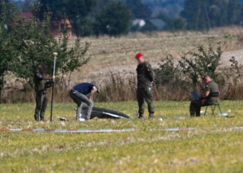 Πολωνοί αξιωματούχοι συγκεντρώνουν τα υπολείμματα ενός ρωσικού drone το οποίο είχε καταπέσει σε ανατολική περιοχή της χώρας το προηγούμενο διάστημα, στην πρώτη από τις παραβιάσεις εναέριων χώρων ξένων χωρών (φωτ.: EPA/Wojtek Jargilo)