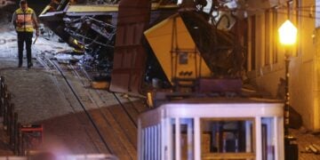 Αστυνομικός στέκεται στη σκηνή του δυστυχήματος με το κατεστραμμένο βαγόνι όπου βρήκαν το θάνατο 15 άνθρωποι (φωτ.: EPA/Miguel A. Lopes)