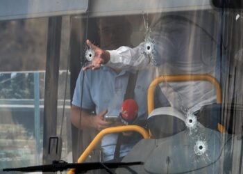 Τρύπες από σφαίρες διακρίνονται στο παρμπρίζ λεωφορείου (φωτ.: EPA/Abir Sultan)