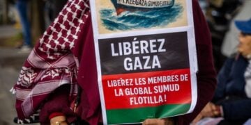 Διαδηλώτρια στο Παρίσι κρατά αφίσα που γράφει «Ελευθερώστε τη Γάζα-Ελευθερώστε τα μέλη του Global Sumud Flotilla» (φωτ.: EPA/Christophe Petit Tesson)
