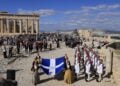 Μέλη της χορευτικής ομάδας του Λυκείου Ελληνίδων με εθνικές ενδυμασίες, κρατώντας τη Σημαία της Απελευθέρωσης και πλαισιωμένα από μαθητές και μαθήτριες της Ιονίου Σχολής, προσήλθαν στο σημείο του ιστού (φωτ.: EUROKINISSI/Γιώργος Κονταρίνης)