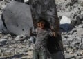 Ένα χαμογελαστό παιδί με φόντο ερείπια στη Λωρίδα της Γάζας (φωτ.: EPA / Mohammed Saber)