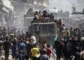 Παλαιστίνιοι συγκεντρώνονται γύρω από φορτηγά που μεταφέρουν ανθρωπιστική βοήθεια στη Χαν Γιουνίς, στο νότιο τμήμα της Λωρίδας της Γάζας (φωτ.: EPA/Haitham Imad)
