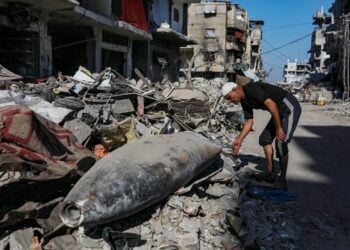 Παλαιστίνιος περιεργάζεται ισραηλινό πύραυλο σε δρόμο της Γάζας (φωτ.: EPA/Mohammed Saber)