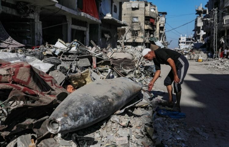 Παλαιστίνιος περιεργάζεται ισραηλινό πύραυλο σε δρόμο της Γάζας (φωτ.: EPA/Mohammed Saber)