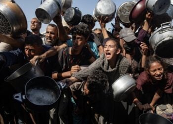 Εκτοπισμένοι Παλαιστίνιοι, ανάμεσά τους παιδιά, προσπαθούν να εξασφαλίσουν φαγητό σε συσσίτιο στη Χαν Γιουνίς (φωτ.: . EPA/Haitham Imad)