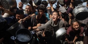 Εκτοπισμένοι Παλαιστίνιοι, ανάμεσά τους παιδιά, προσπαθούν να εξασφαλίσουν φαγητό σε συσσίτιο στη Χαν Γιουνίς (φωτ.: . EPA/Haitham Imad)