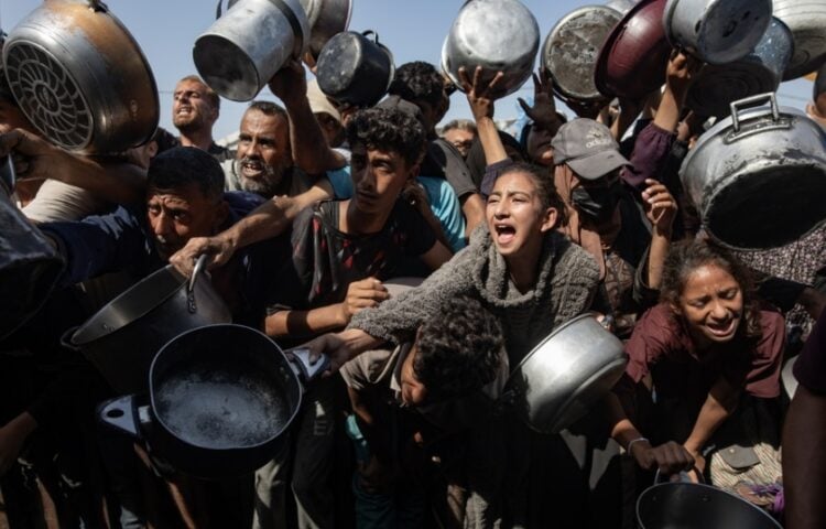 Εκτοπισμένοι Παλαιστίνιοι, ανάμεσά τους παιδιά, προσπαθούν να εξασφαλίσουν φαγητό σε συσσίτιο στη Χαν Γιουνίς (φωτ.: . EPA/Haitham Imad)