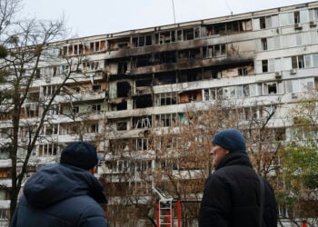 Ουκρανοί κοιτούν τις ζημιές σε εννιαώροφη πολυκατοικία μετά από ρωσικό πλήγμα στη διάρκεια της νύχτας. Κίεβο, 25 Νοεμβρίου 2025 (φωτ.: EPA / Sergey Kozlov)