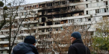 Ουκρανοί κοιτούν τις ζημιές σε εννιαώροφη πολυκατοικία μετά από ρωσικό πλήγμα στη διάρκεια της νύχτας. Κίεβο, 25 Νοεμβρίου 2025 (φωτ.: EPA / Sergey Kozlov)