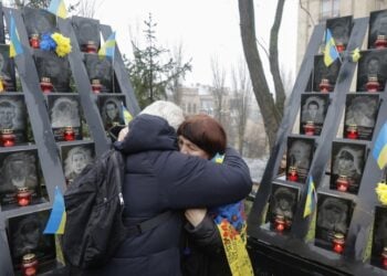 Ουκρανές αγκαλιάζονται μπροστά από μνημείο πεσόντων κοντά στην πλατεία Ανεξαρτησίας του Κιέβου (φωτ.: EPA/Sergey Dolzhenko)