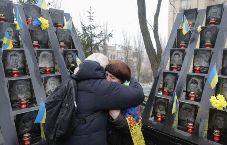 Ουκρανές αγκαλιάζονται μπροστά από μνημείο πεσόντων κοντά στην πλατεία Ανεξαρτησίας του Κιέβου (φωτ.: EPA/Sergey Dolzhenko)