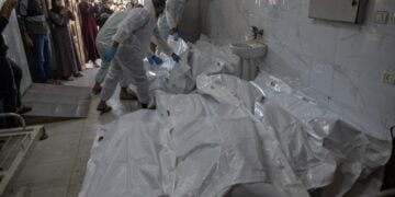 Στελέχη του υπουργείου Υγείας της Γάζας ετοιμάζονται να θάψουν τις σορούς Παλαιστίνιων μαχητών που τους παρέδωσε ο Ερυθρός Σταυρός από το Ισραήλ (φωτ.: EPA/Haitham Imad)