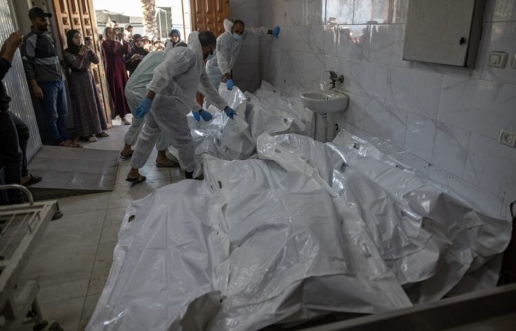 Στελέχη του υπουργείου Υγείας της Γάζας ετοιμάζονται να θάψουν τις σορούς Παλαιστίνιων μαχητών που τους παρέδωσε ο Ερυθρός Σταυρός από το Ισραήλ (φωτ.: EPA/Haitham Imad)