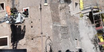 Στην αριστερή πλευρά του Πύργου των Κόμηδων πυροσβέστες προσπαθούν να απεγκλωβίσουν εργάτη, ενώ δεξιά διακρίνονται κομμάτια του τοίχου τα οποία καταρρέουν (φωτ.: EPA/Maurizio Brambatti)