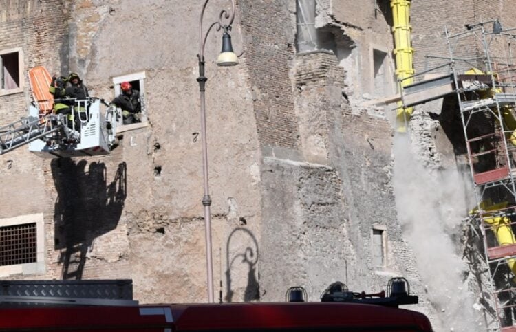 Στην αριστερή πλευρά του Πύργου των Κόμηδων πυροσβέστες προσπαθούν να απεγκλωβίσουν εργάτη, ενώ δεξιά διακρίνονται κομμάτια του τοίχου τα οποία καταρρέουν (φωτ.: EPA/Maurizio Brambatti)