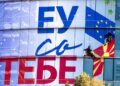 Εργάτες κολλούν τη νέα πρόσοψη των γραφείων της ΕΕ στα Σκόπια, η οποία αναγράφει «Η Ευρωπαϊκή Ένωση μαζί σου» (φωτ. αρχείου: EPA/Georgi Licovski)