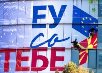 Εργάτες κολλούν τη νέα πρόσοψη των γραφείων της ΕΕ στα Σκόπια, η οποία αναγράφει «Η Ευρωπαϊκή Ένωση μαζί σου» (φωτ. αρχείου: EPA/Georgi Licovski)