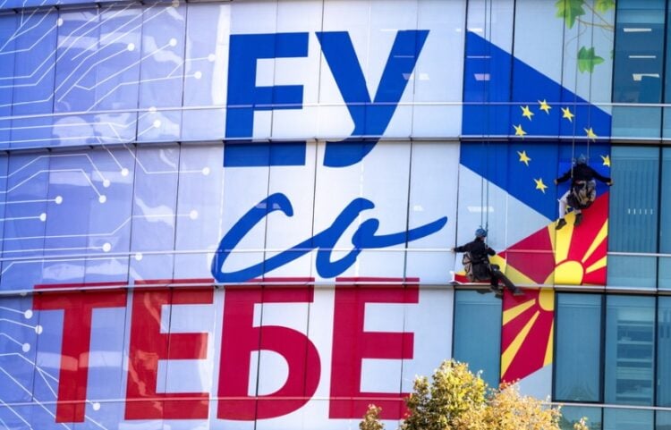 Εργάτες κολλούν τη νέα πρόσοψη των γραφείων της ΕΕ στα Σκόπια, η οποία αναγράφει «Η Ευρωπαϊκή Ένωση μαζί σου» (φωτ. αρχείου: EPA/Georgi Licovski)