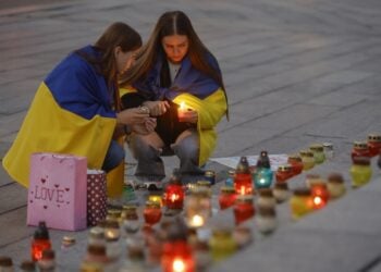 Ουκρανές ανάβουν κεριά σε αυτοσχέδιο βωμό στο Κίεβο για τους  νεκρούς στρατιώτες και εθελοντές που σκοτώθηκαν στη διάρκεια των μαχών (φωτ.: EPA/Sergey Dolzhenko)