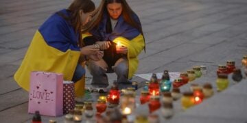 Ουκρανές ανάβουν κεριά σε αυτοσχέδιο βωμό στο Κίεβο για τους  νεκρούς στρατιώτες και εθελοντές που σκοτώθηκαν στη διάρκεια των μαχών (φωτ.: EPA/Sergey Dolzhenko)