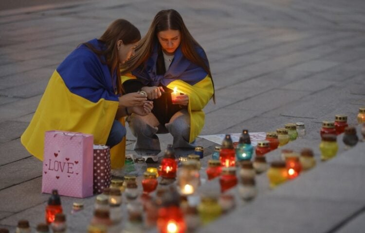 Ουκρανές ανάβουν κεριά σε αυτοσχέδιο βωμό στο Κίεβο για τους  νεκρούς στρατιώτες και εθελοντές που σκοτώθηκαν στη διάρκεια των μαχών (φωτ.: EPA/Sergey Dolzhenko)