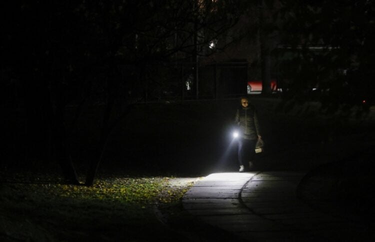 Ουκρανός περπατά με τον φακό του κινητού τηλεφώνου στη διάρκεια πολύωρης διακοπής ρεύματος στο Κίεβο. Η κοινή γνώμη είναι εξοργισμένη με το σκάνδαλο διαφθοράς στον ενεργειακό τομέα, δεδομένων των προβλημάτων στην ηλεκτροδότηση λόγω του πολέμου με τη Ρωσία (φωτ.: EPA/Sergey Dolzhenko)