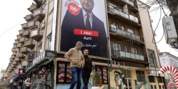 Κοσοβάροι προσπερνούν προεκλογική γιγαντοαφίσα του Άλμπιν Κούρτι στην Πρίστινα (φωτ.: EPA/Georgi Licovski)