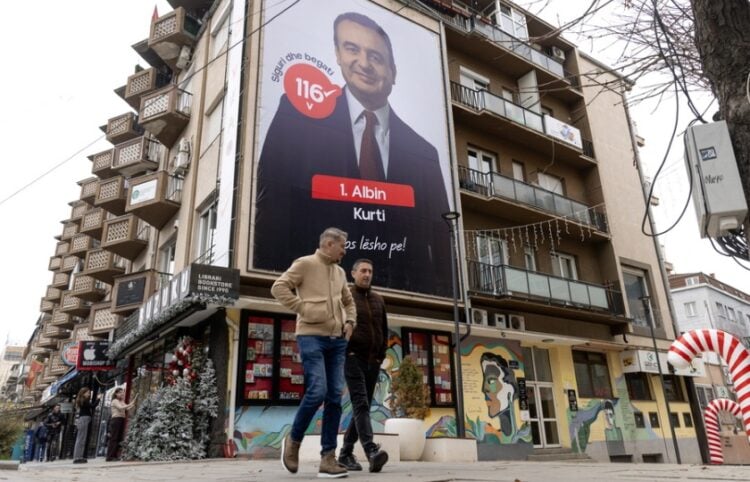 Κοσοβάροι προσπερνούν προεκλογική γιγαντοαφίσα του Άλμπιν Κούρτι στην Πρίστινα (φωτ.: EPA/Georgi Licovski)