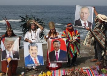 Ομάδα σαμάνων και θεραπευτών κρατούν εικόνες ηγετών κρατών κατά τη διάρκεια τελετουργικού, σε παραλία στη λίστα του Περού (φωτ.: EPA/Paolo Aguilar)