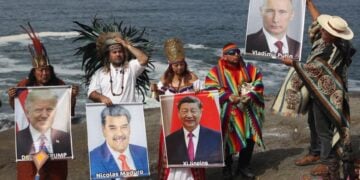 Ομάδα σαμάνων και θεραπευτών κρατούν εικόνες ηγετών κρατών κατά τη διάρκεια τελετουργικού, σε παραλία στη λίστα του Περού (φωτ.: EPA/Paolo Aguilar)