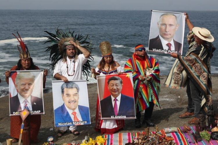 Ομάδα σαμάνων και θεραπευτών κρατούν εικόνες ηγετών κρατών κατά τη διάρκεια τελετουργικού, σε παραλία στη λίστα του Περού (φωτ.: EPA/Paolo Aguilar)