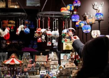 Γερμανίδα κοιτά χριστουγεννιάτικα στολίδια σε αγορά του Βερολίνου.Τέσσερις στις πέντε επιχειρήσεις που οδηγούνται σε πτώχευση απασχολούν κάτω από 10 εργαζόμενους (φωτ.: EPA/Clemens Bilan)