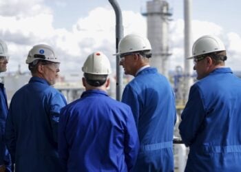 Ο Γερμανός καγκελάριος Φρίντριχ Μερτς (δεύτερος από δεξιά) στη διάρκεια παλιότερης επίσκεψής του σε εργοστάσιο στο Ντίσελντορφ (φωτ.: EPA/Christopher Neundorf)