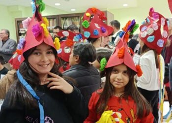 Παρόλο που στο θίασο των Μωμόγερων δεν συμμετέχουν γυναίκες, αυτές εδώ οι μικρές φόρεσαν τις χαρακτηριστικές περικεφαλαίες, έστω και από χαρτί. Στιγμιότυπό από τη δράση στη βιβλιοθήκη της Πτολεμαΐδας (φωτ.: Facebook / Κλαίρη Πλαγερινού)