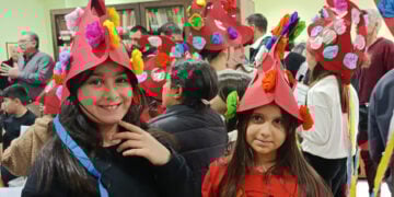 Παρόλο που στο θίασο των Μωμόγερων δεν συμμετέχουν γυναίκες, αυτές εδώ οι μικρές φόρεσαν τις χαρακτηριστικές περικεφαλαίες, έστω και από χαρτί. Στιγμιότυπό από τη δράση στη βιβλιοθήκη της Πτολεμαΐδας (φωτ.: Facebook / Κλαίρη Πλαγερινού)