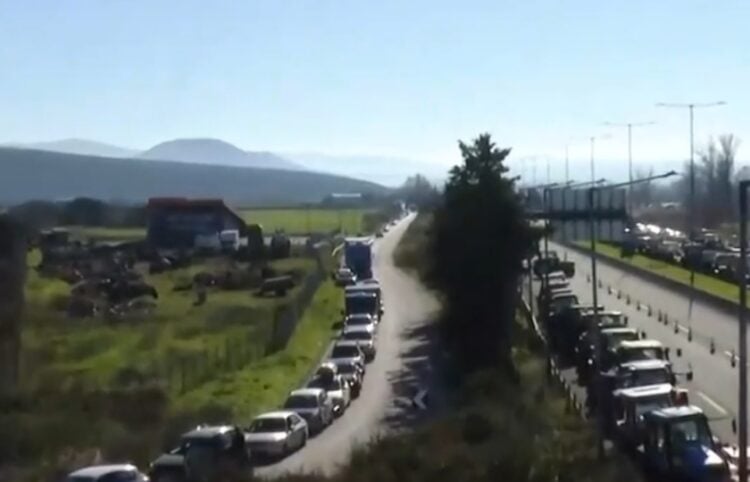 Αριστερά διακρίνονται τα ΙΧ που κινούνται υποχρεωτικά σε ένα ρεύμα κυκλοφορίας και έχουν σχηματίσει μεγάλη ουρά, ενώ τα τρακτέρ βρίσκονται επί της εθνικής οδού (φωτ.: glomex)