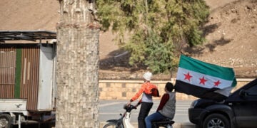 Παιδιά στη Χάμα κρατούν τη νέα σημαία της Συρίας, κατά τη διάρκεια των εορτασμών για τον έναν χρόνο από την απελευθέρωση της πόλης, 5 Δεκεμβρίου 2025 (φωτ.: EPA / Bilal al-Hammoud)