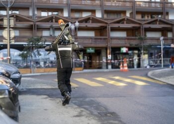 Σκιέρ περπατά κοντά στο μπαρ όπου σημειώθηκε η φονική πυρκαγιά στο Κραν Μοντανά (φωτ.: EPA/Alessandro Della Valle)