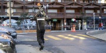 Σκιέρ περπατά κοντά στο μπαρ όπου σημειώθηκε η φονική πυρκαγιά στο Κραν Μοντανά (φωτ.: EPA/Alessandro Della Valle)